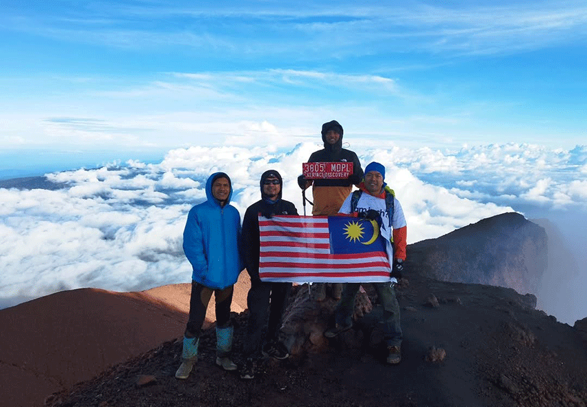 Pendaki Malaysia berfoto di puncak Gunung Kerinci bersama Kerinci Earth. (Sumber Foto: Instagram @kerinciearth)