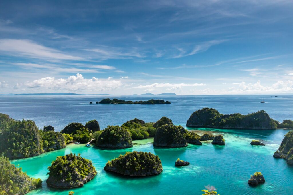 Pulau kecil di Raja Ampat yang dikelilingi oleh badan air pada siang hari. 